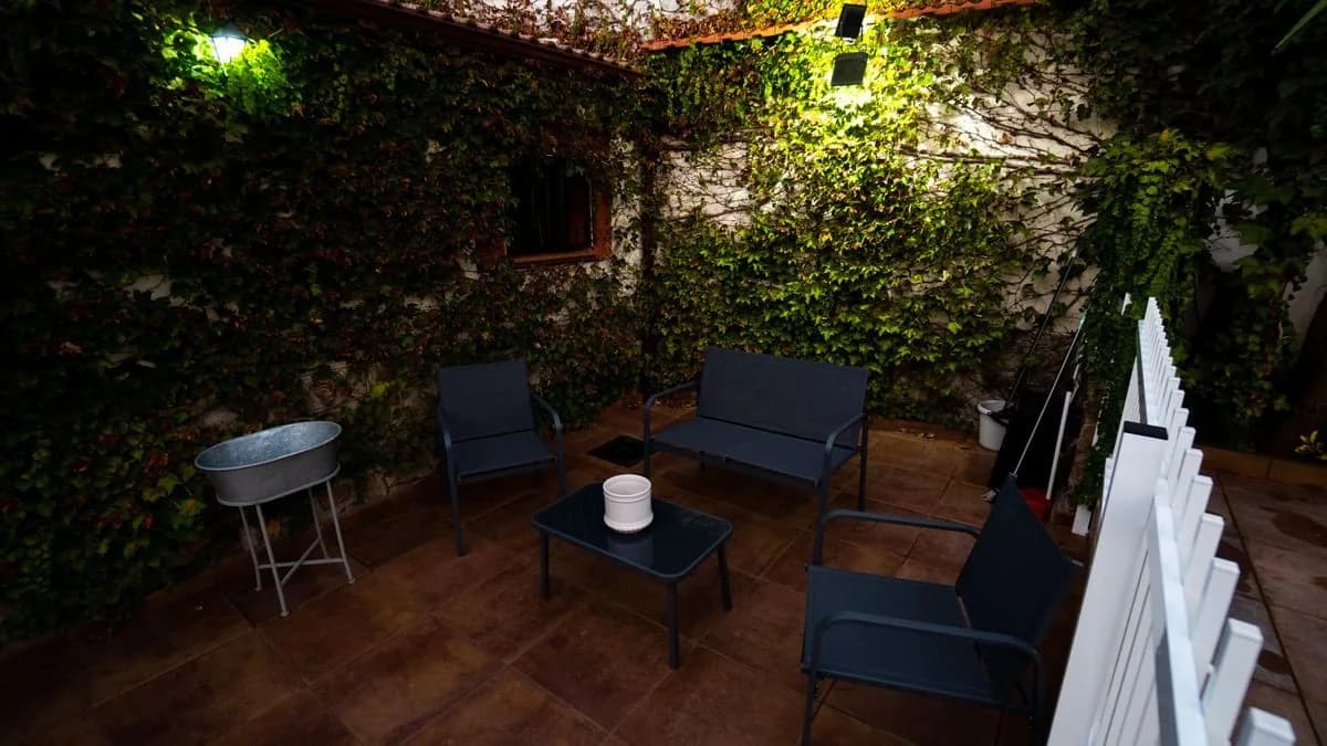Rincón del jardín con sillones, iluminado de noche