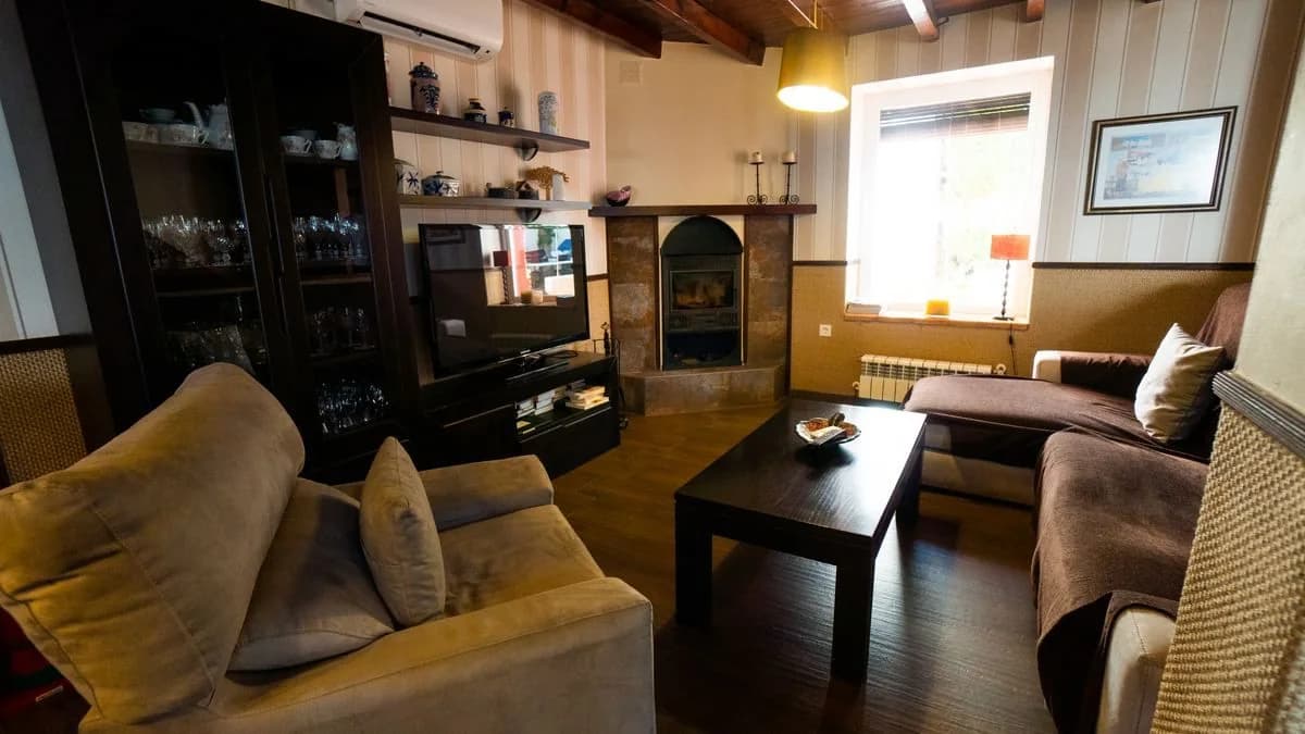 Salón de Las Parras con sofás y chimenea encendida