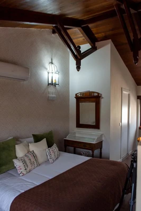 Cama de la suite bajo el techo inclinado de madera