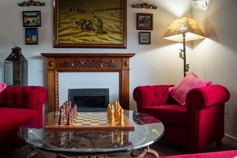 Zona de estar de la suite superior con sofás rojos y chimenea