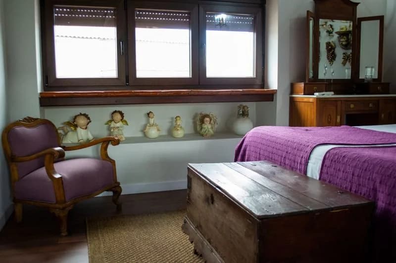 Baúl antiguo y butaca de la suite superior